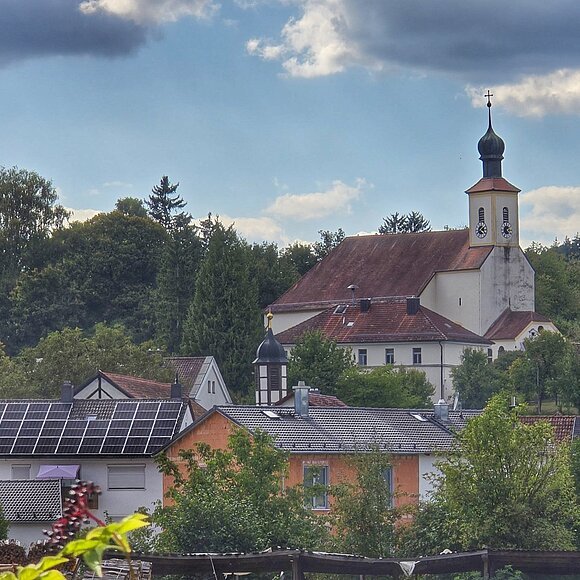 Die Waltinger Kirche von weitem zu sehen, wie sie über die Dächer herausragt.